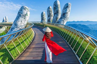 Asian female tourist walks on golden bridge in Ba Na Hills, Danang, Vietnam Asian female tourist walks on golden bridge in Ba Na Hills, Danang, Vietnam