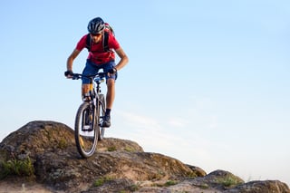 riding the bike down the rock on the blue sky