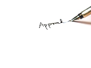 hand signing approval word one white paper