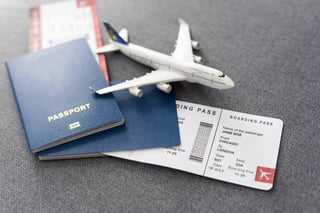 toy airplane and passport with tickets on gray background