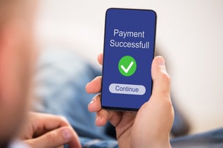 Close up of a person's hand showing payment successful message