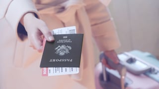 Girl With A Suitcase Holds American Passport And Boarding Pass