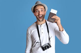Young Man With Camera And Ticket On Blue Background