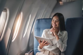 Asian Young Woman Using Tablet Sitting Near Windows At First Class
