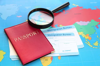 Magnifying Glass And Passport With Arrival Cards Of Immigration Bureau