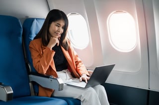 Professional Woman Working On A Laptop During A Flight Showcasing