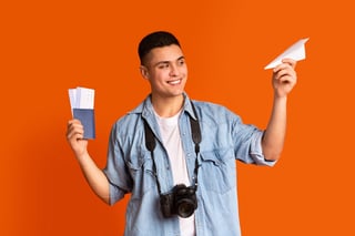 Traveler With Camera Holding Passport Flight Tickets And Paper Airplane