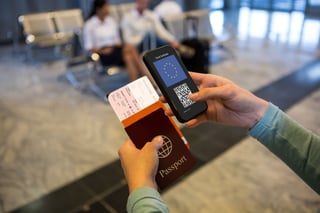 Woman At Airport Holding Documents And Smartphone With Covid